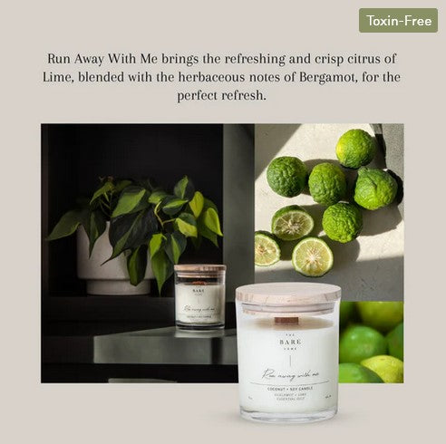This 'Run away with me' essential oil candle in a jar scented with bergamot and lime is shown in front of some limes and sits on a table in front of a plant.