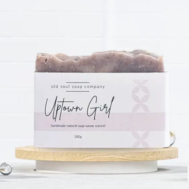 vegan essential oil 180 g bar soap handcrafted in canada by the old soul soap company sitting on a wood tray with an uptown girl label