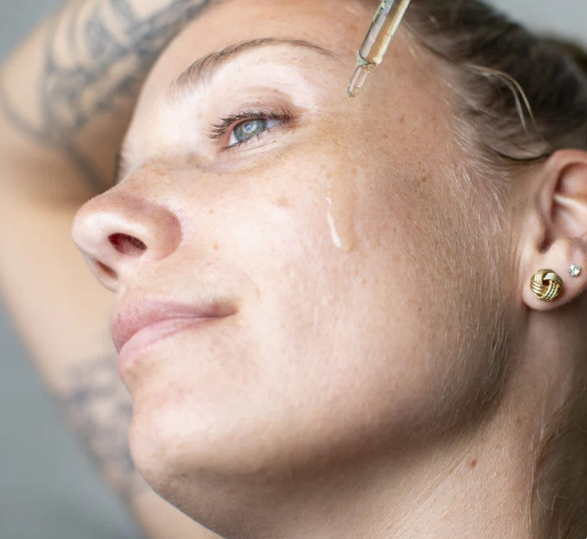 Woman applying Leaf Shave Calming Serum to face for soothing hydration