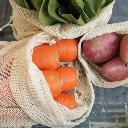 Set of three small, medium and large mesh produce bags filled with carrots, sweet potatoes and boston lettuce