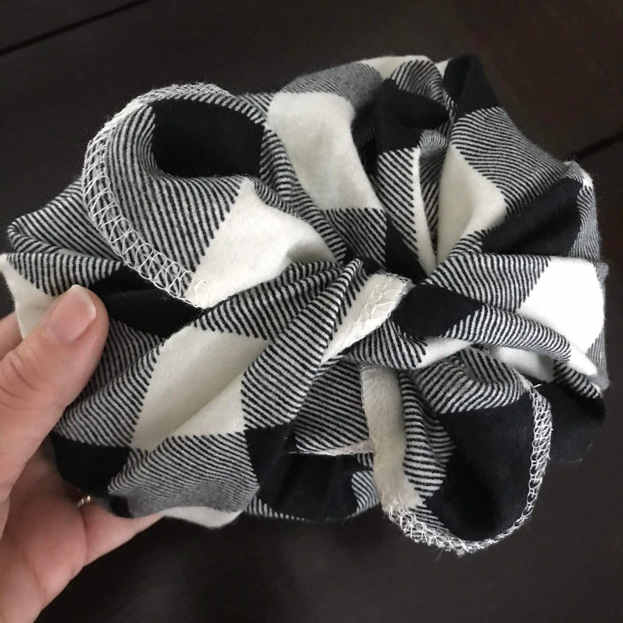A small gift wrapped in black and white plaid cotton flannel gift wrap from the Canadian brand Cheeks Ahoy