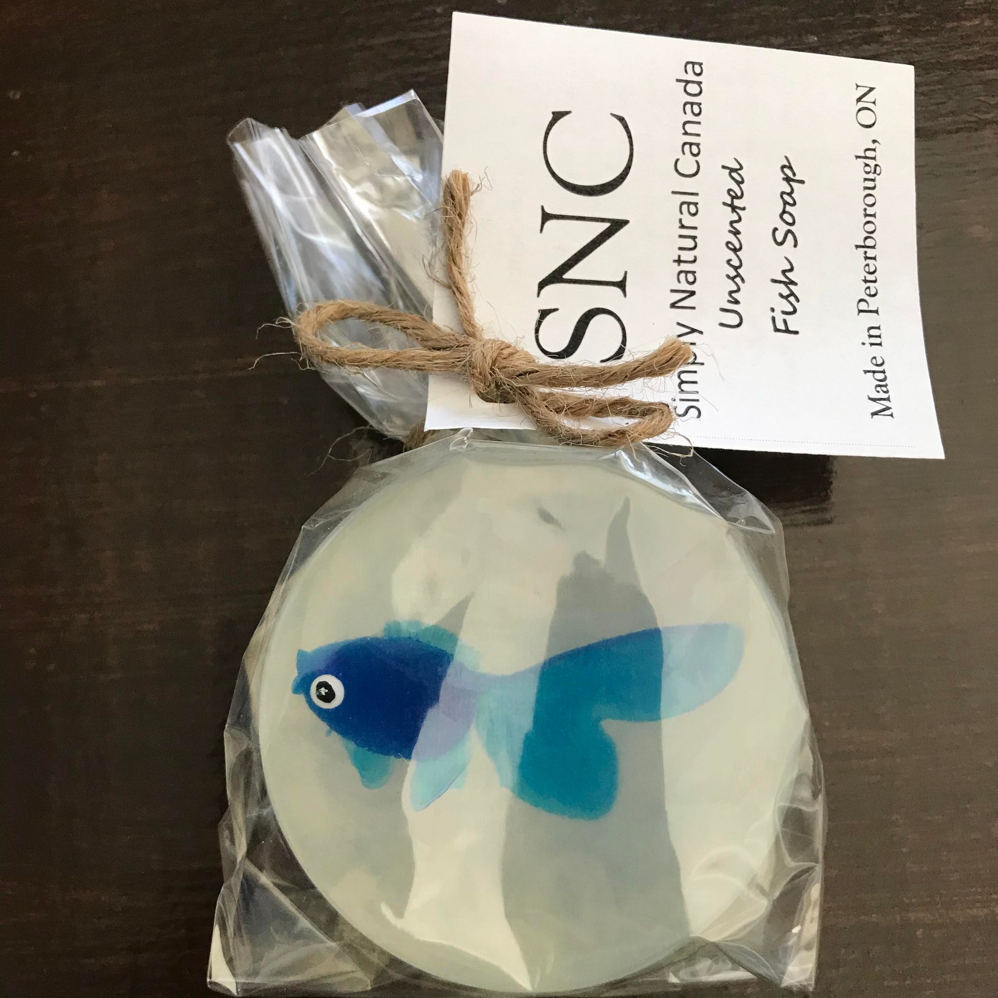 Blue vinyl fish inside a clear round vegetable glycerin soap packaged inside a compostable bag and made in Canada by Simply Natural Canada