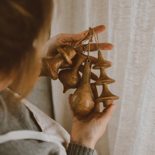 Handcrafted set of 4 sustainable wood tree decorations made in India come in a brown Kraft gift box.