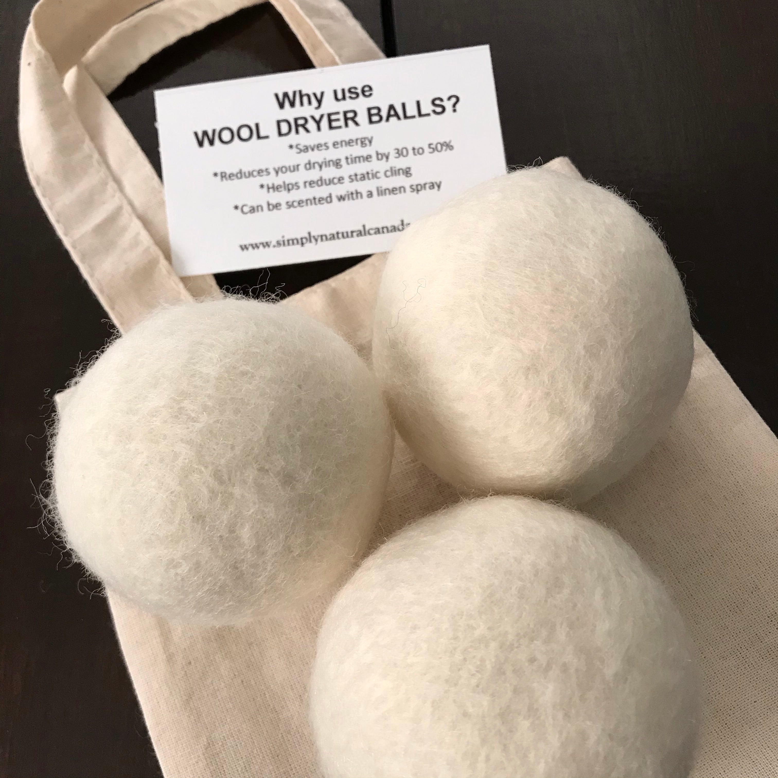set of 3 canadian made white 100 percent wool dryer balls sold in a cloth bag