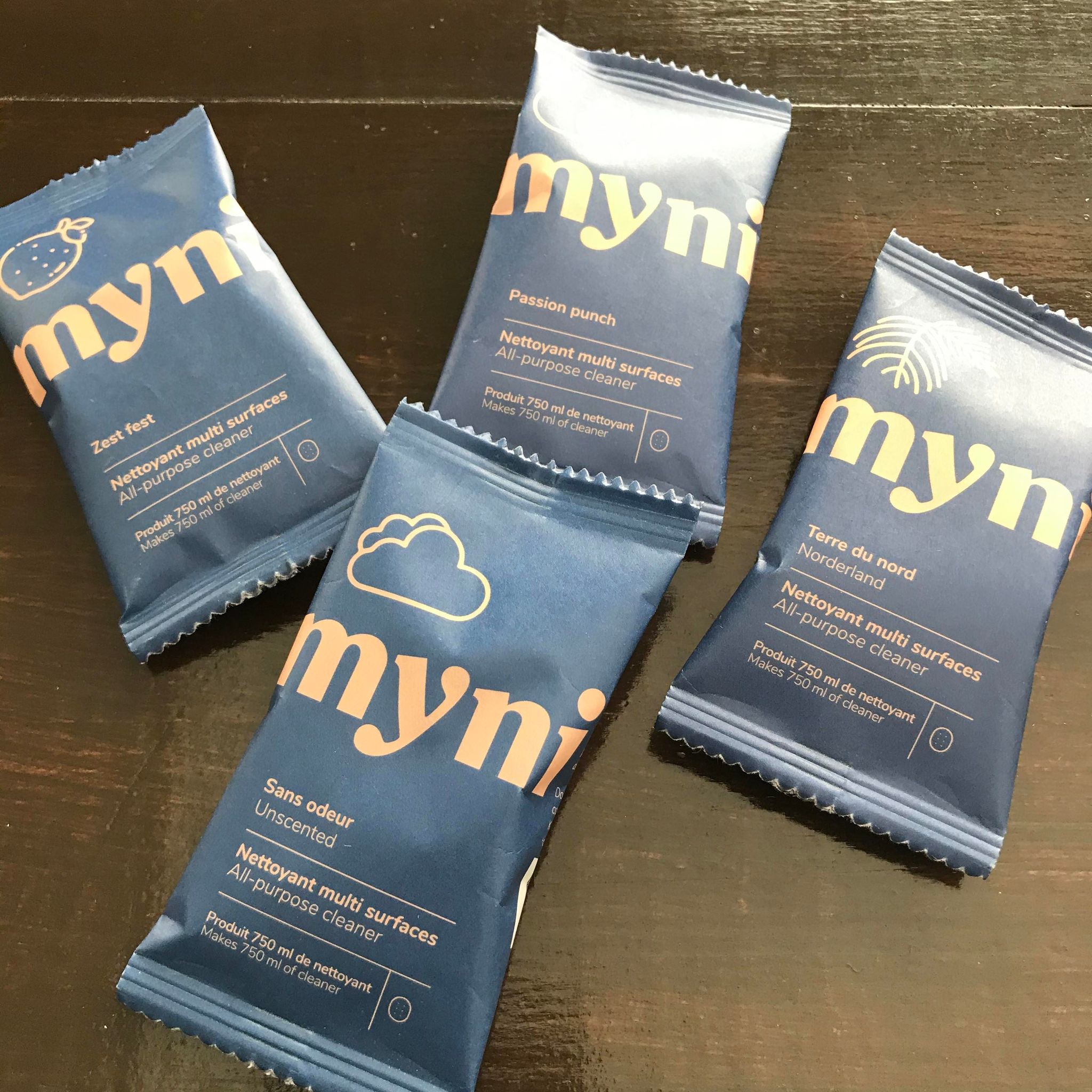 all purpose cleaning concentrate tablets made in canada by myni and available unscented and in nordeland (black spruce), zest fest (lemon mint) and passion punch (grapefruit mango) scents in compostable pouches.