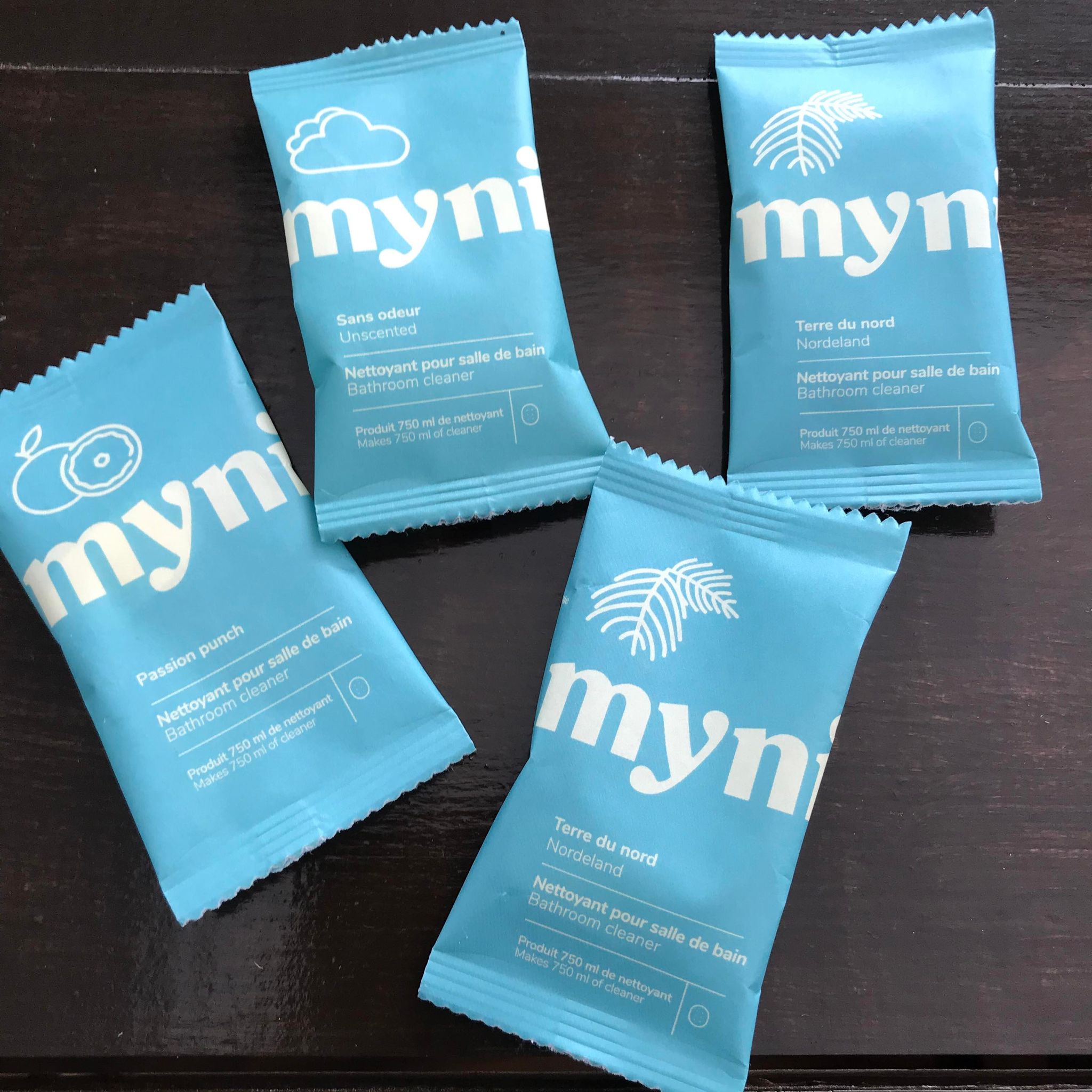 Bathroom cleaning concentrate tablets made in canada by myni and available in unscented as well as scented options - Norderland (black spruce), Zest Fest (lemon mint) and Passion Punch (grapefruit mango) scents in compostable pouches