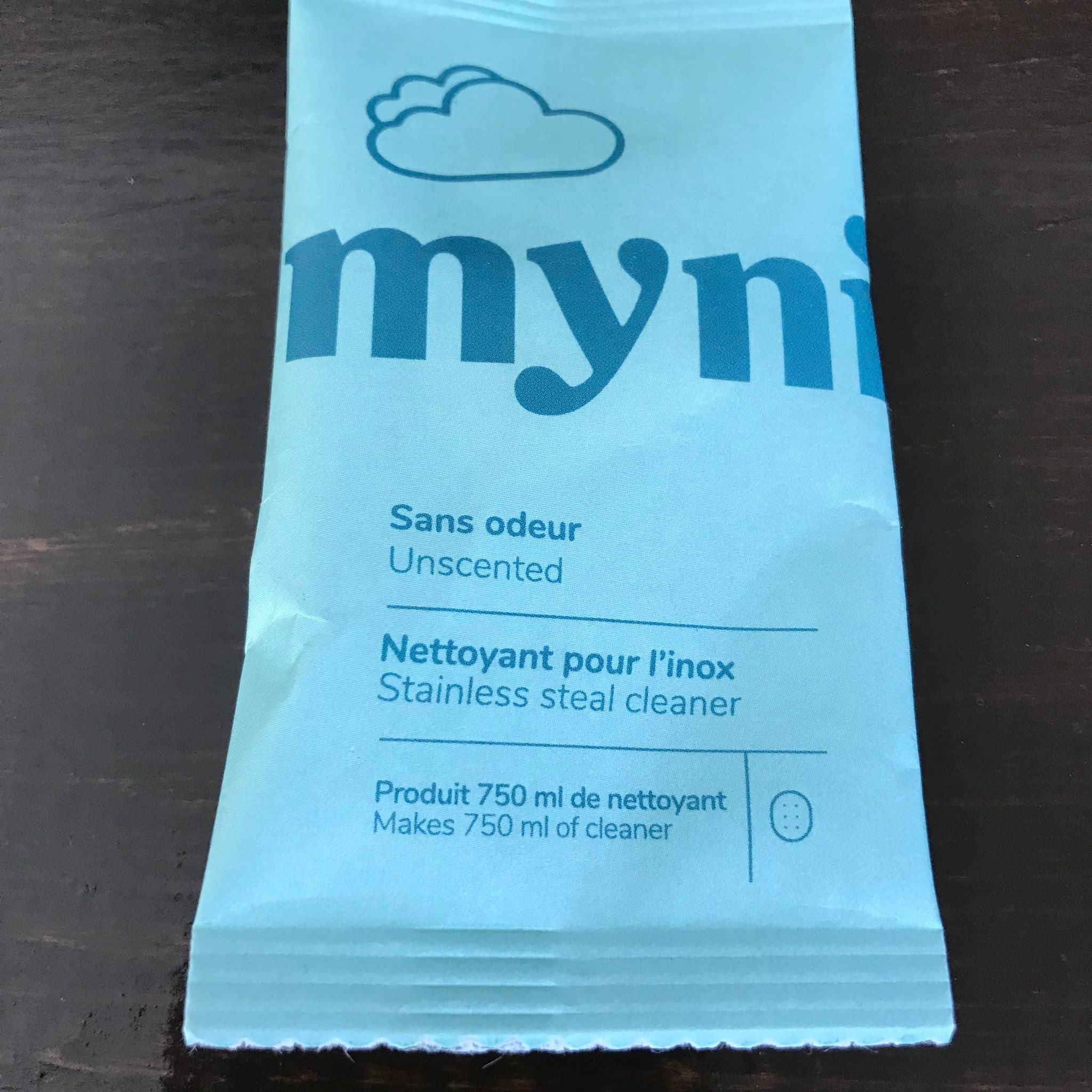 An individual unscented stainless steel cleaner tablet in compostable pouch made in Canada by myni makes up to 750 ml of cleaner just by adding water and a tablet to a spray bottle