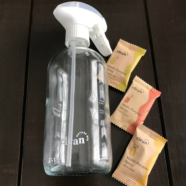 nature bee clean empty clear glass multi-use bottle with white spray top alongside three multi-purpose cleaning tablet scent options in bergamot lime, sweet citrus and fresh lemonsold separately