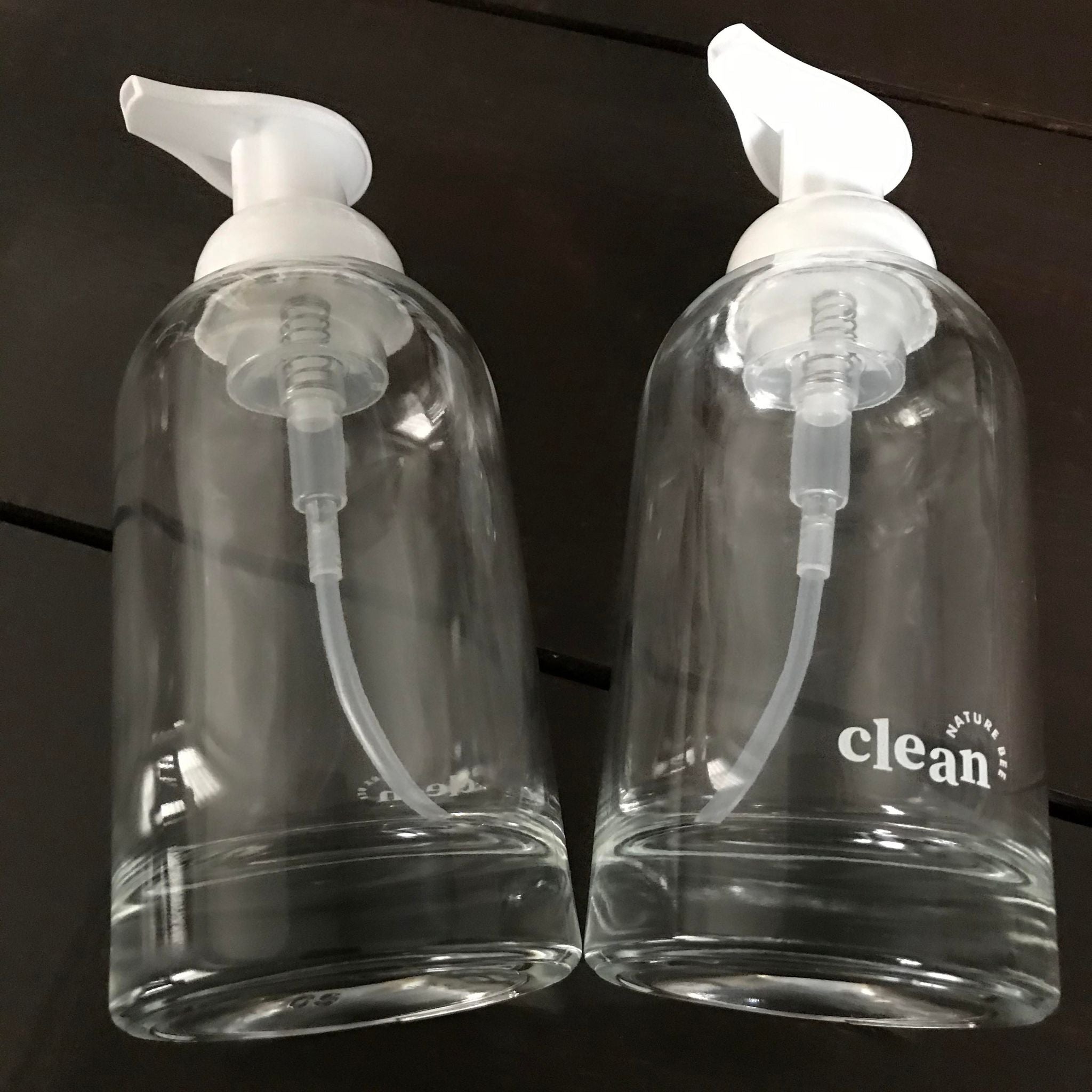 refillable clear glass hand soap foamer bottles with white pump top and white nature bee clean lettering at the bottom front or back of the bottles