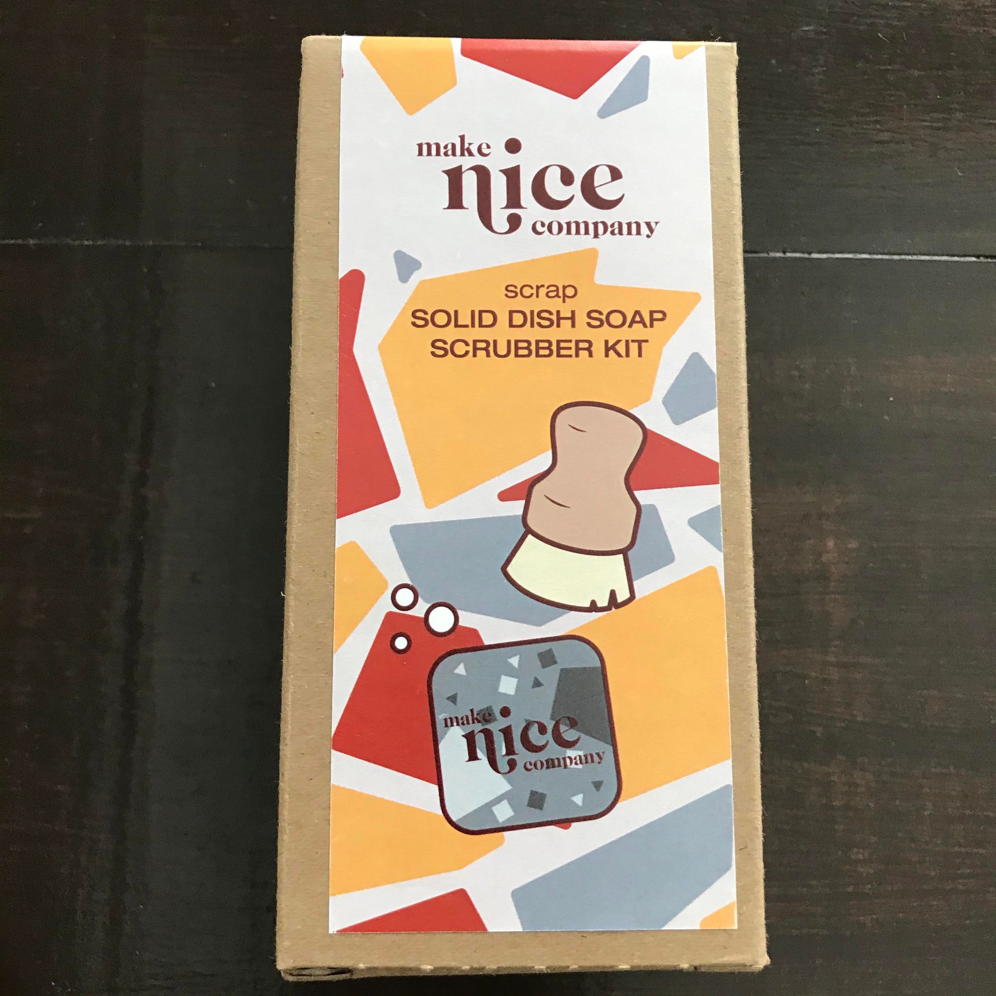 Scrap solid dish soap block and wood pot scrubber brush set made in Canada by the Make Nice Company and packaged in a brown cardboard box