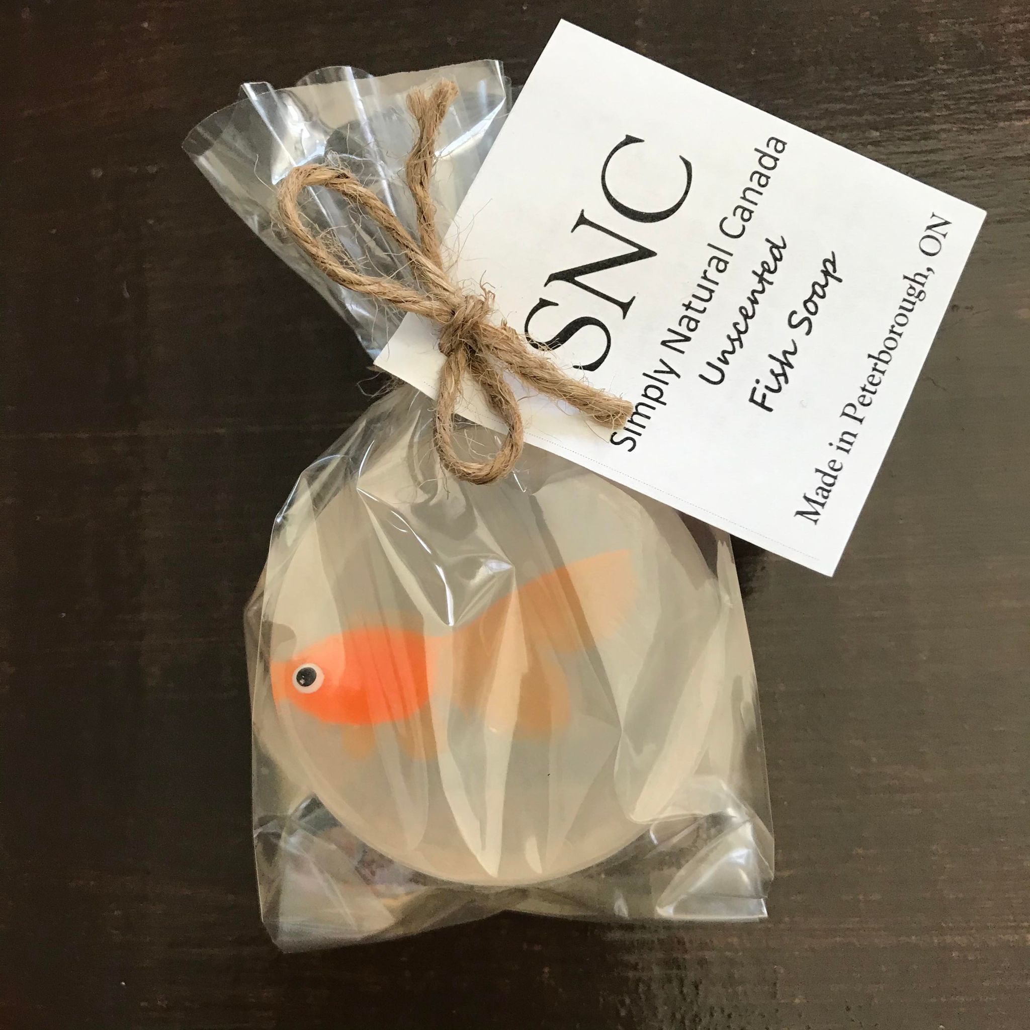Orange vinyl fish inside a clear round vegetable glycerin soap packaged inside a compostable bag and made in Canada by Simply Natural Canada