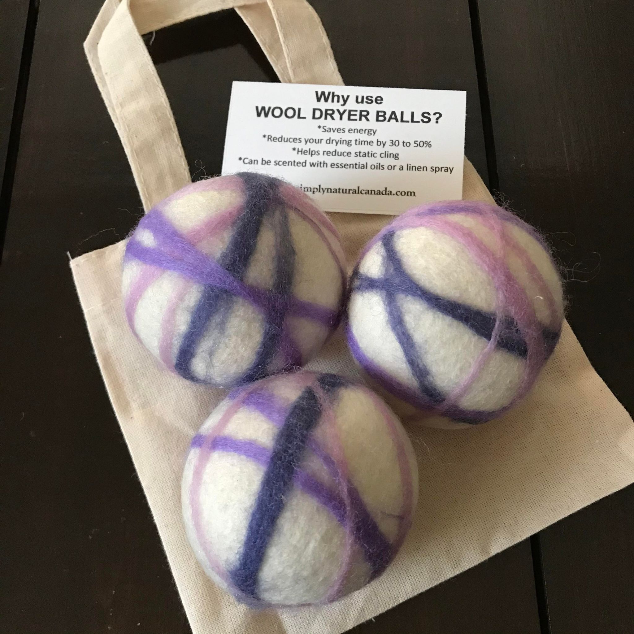 set of 3 canadian made white, purple and pink 100 percent wool dryer balls sold in a cloth bag
