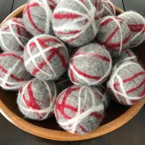 grey red and white canadian made simply natural canada 100 percent wool dryer balls sold individually as pictured in a large wood bowl or in sets of three in a cotton bag