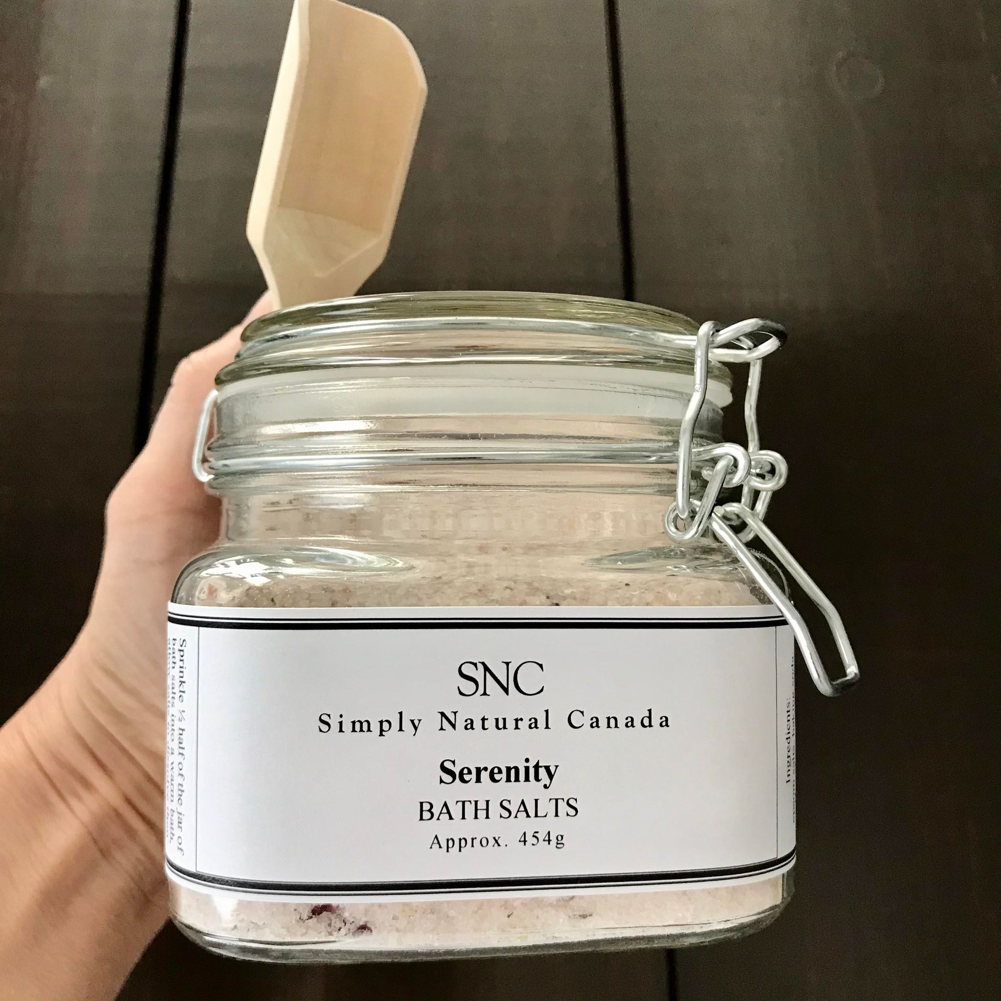 candian made simply natural canada natural floral serenity bath salts in a glass jar with dried flowers and a wooden scoop 